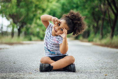 Portrait of girl sitting on road