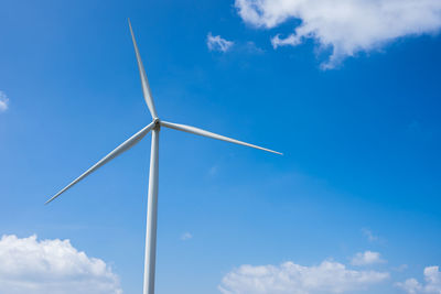 Low angle view of windmill against blue sky