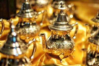 Close-up of golden morrocan coffee pots on table