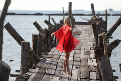 Rear view of woman standing on railing