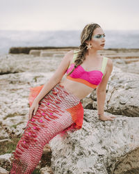 Portrait of young woman standing at beach