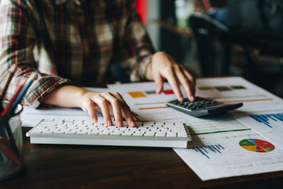 Midsection of woman using laptop on table