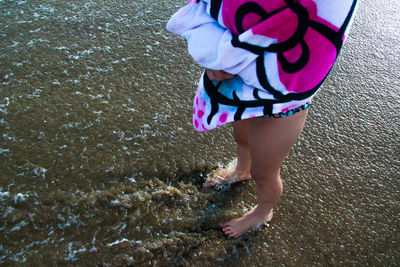Low section of woman standing in water