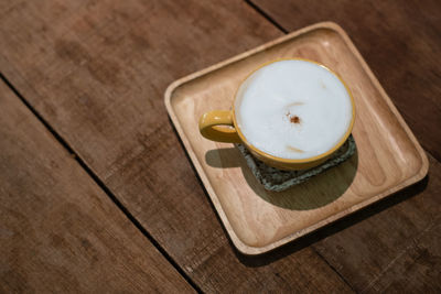 Top view of cup of coffee on wooden table