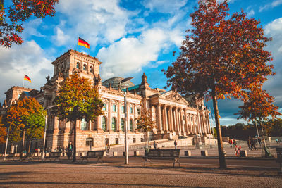 Buildings in city against cloudy sky