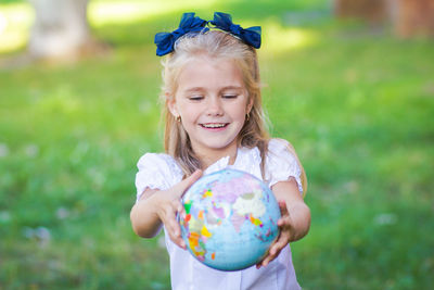 Little girl schoolgirl studying the globe