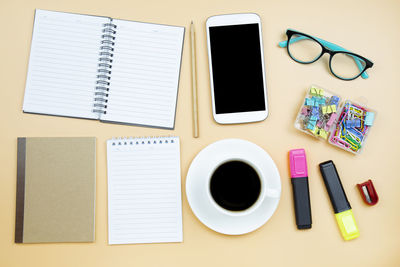 Directly above shot of various objects over yellow background