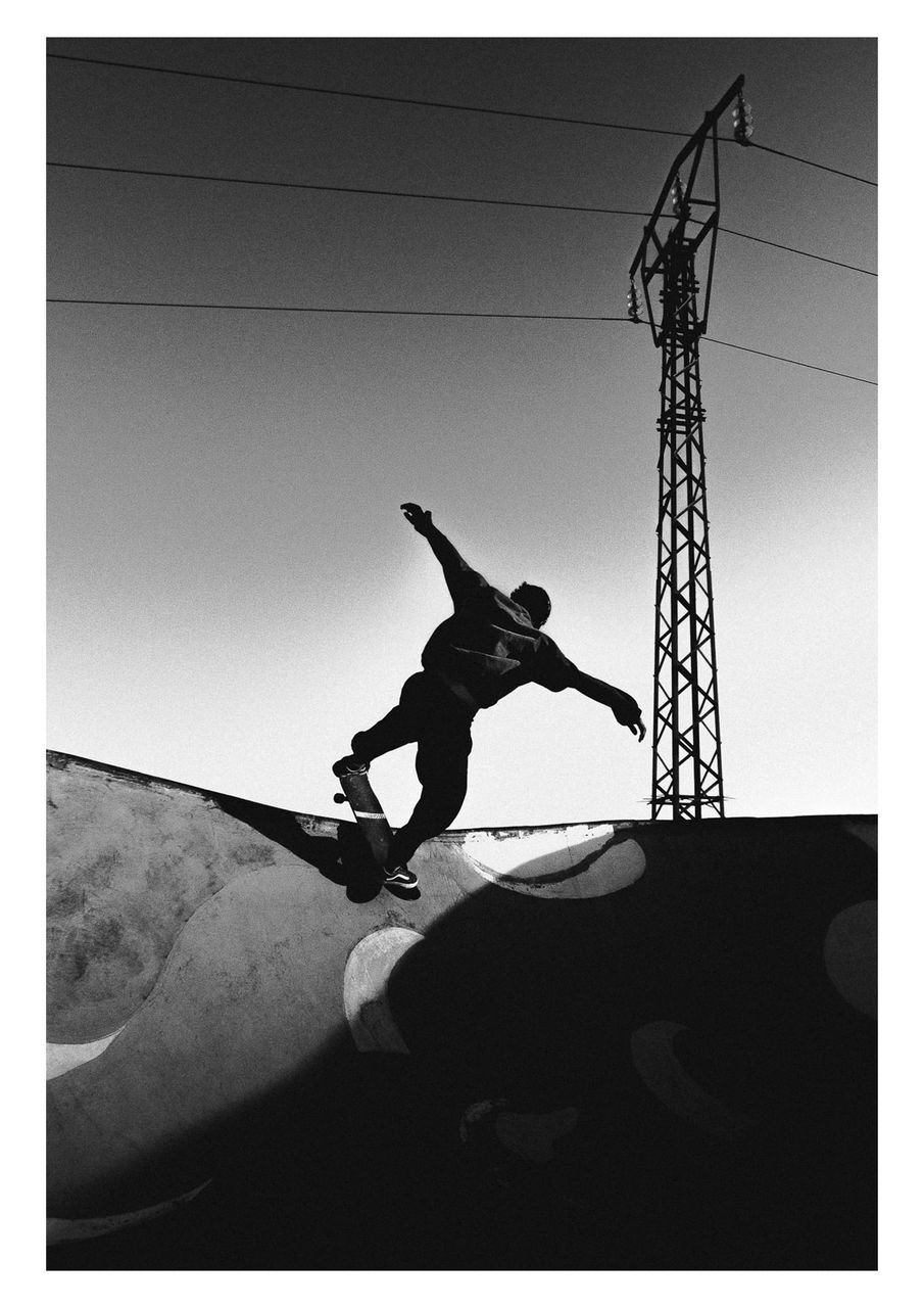 LOW ANGLE VIEW OF SILHOUETTE MAN CLIMBING AGAINST SKY