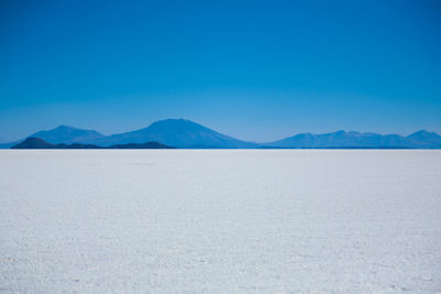 Scenic view of desert against clear blue sky