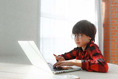 Boy using laptop at home