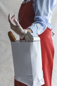 Midsection of woman holding umbrella standing outdoors