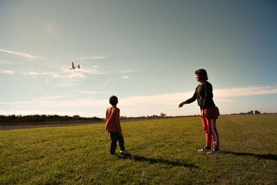 Mother and son on land against sky