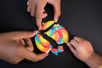 Midsection of woman holding multi colored candies