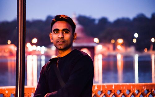 Portrait of young man standing in city at night