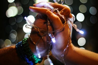 Close-up of woman holding illuminated lighting equipment