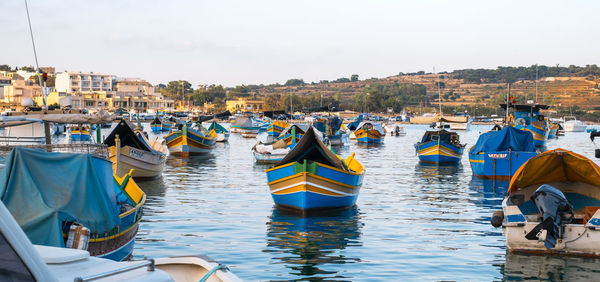 Marsaxlokk city, malta - july 21, 2019. traditional fishing boats moored at marsaxlokk harbor, malta