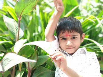 Portrait of boy with leaves in park