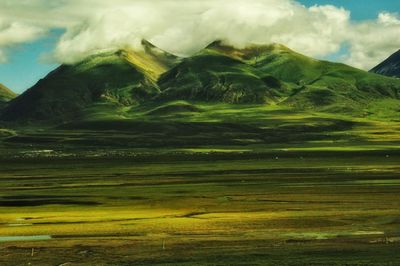 Scenic view of landscape against cloudy sky