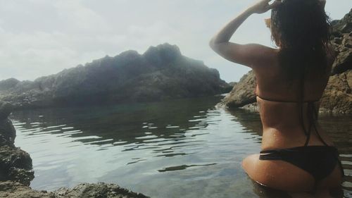 Rear view of woman standing in water