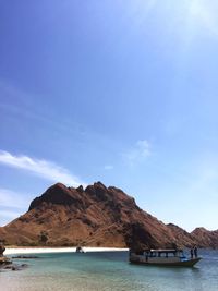 Scenic view of sea and mountains against blue sky