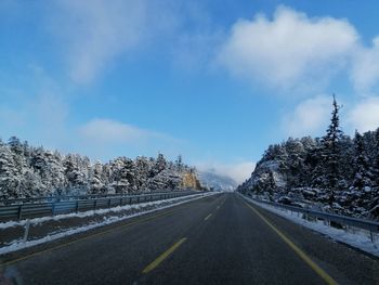 Road amidst trees against sky