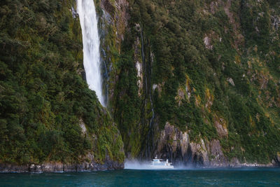 Scenic view of waterfall by sea