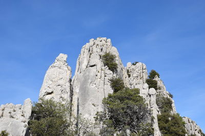 Low angle view of rocks against blue sky