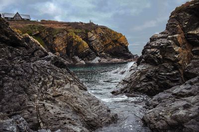 Scenic view of rocks in sea against sky