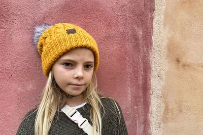 Portrait of a smiling girl against wall