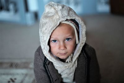 Portrait of cute boy in hood at home