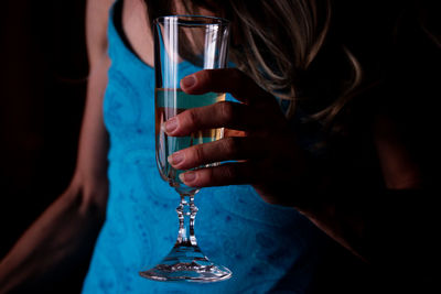 Midsection of woman holding wineglass