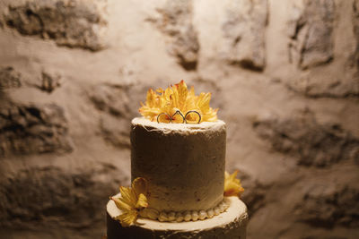 Cake with yellow flowers against wall