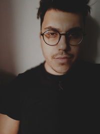Portrait of young man wearing eyeglasses at home