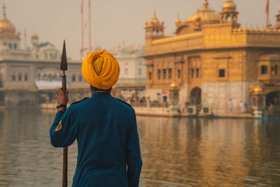 Rear view of man standing in city against buildings