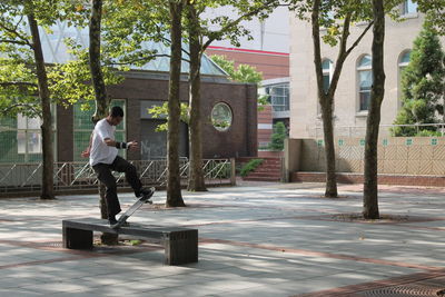 Side view of man skateboarding on street in city