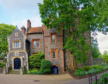 Old building by trees against sky