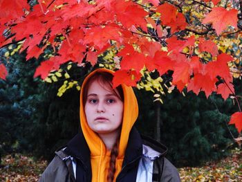 Portrait of woman standing against yellow flowers