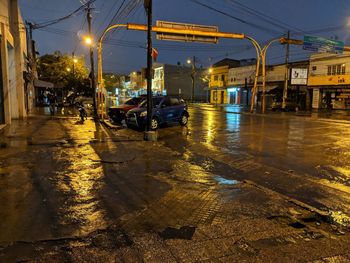 Illuminated city street during rainy season at night