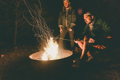 Friends by bonfire at camping
