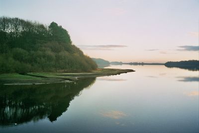 Scenic view of lake against sky at sunset