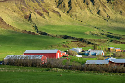 Scenic view of agricultural field by houses and mountain