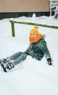 Girl playing on snow covered field during winter