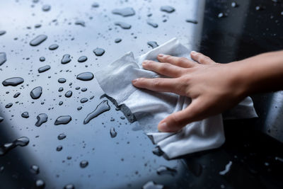 Midsection of man touching wet glass