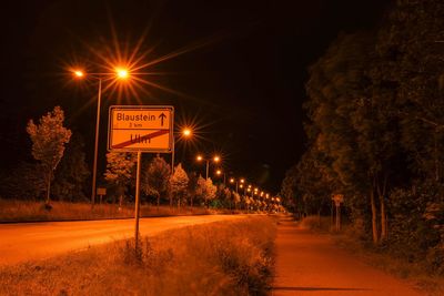 Illuminated road sign at night