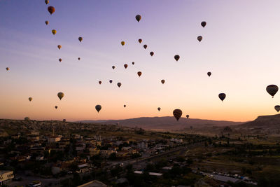 Silhouette of hot air balloons against sky during sunset