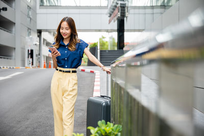 Portrait of young woman standing in city