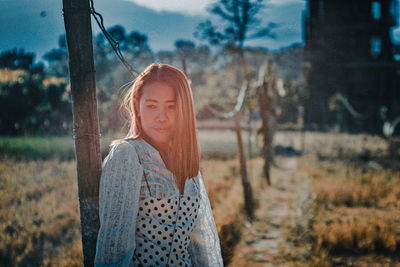 Portrait of young woman standing on field