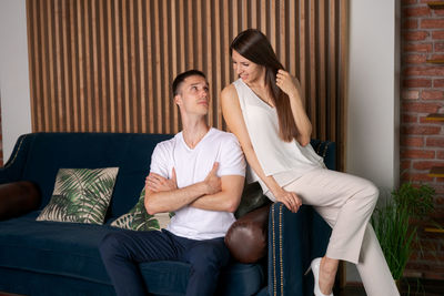 Smiling caucasian man and woman hugging on sofa, spending romantic intimate