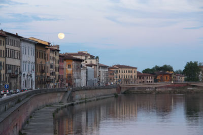 Canal amidst buildings in city against sky