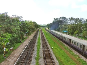 Railway tracks amidst trees against clear sky